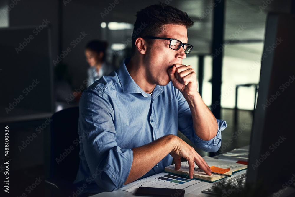 The late shift can get exhausting. Cropped shot of a young attractive businessman working late in th