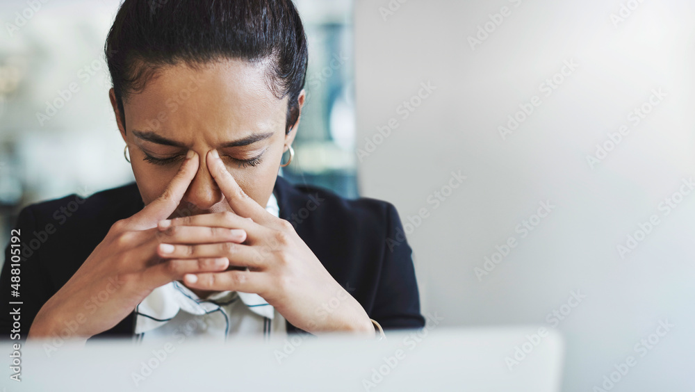 Its too much for one person to handle. Shot of a young businesswoman looking stressed while working 