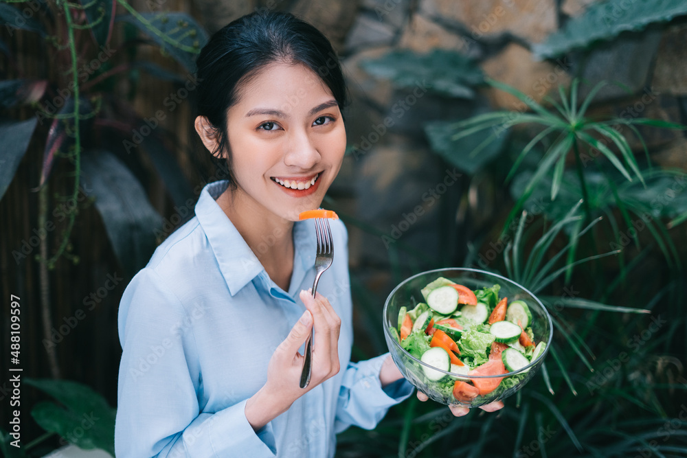 美丽的年轻亚洲女人享用沙拉早餐