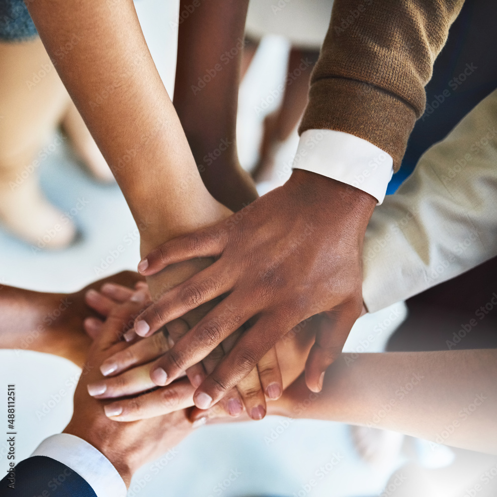 Teams dont work without teamwork. Cropped shot of a group of businesspeople piling their hands on to