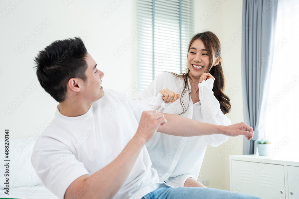 Asian young loving couple dance with music together in bedroom at home. 