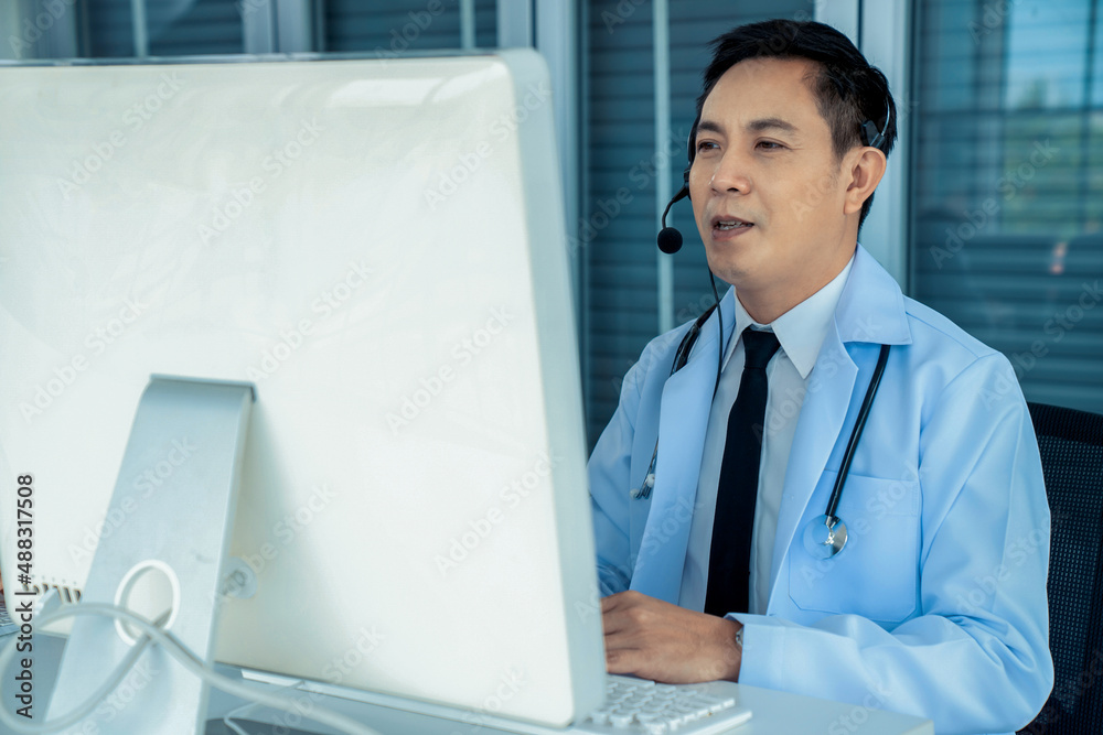 Doctor wearing headset talking actively on video call in a clinic or hospital . Concept of telehealt