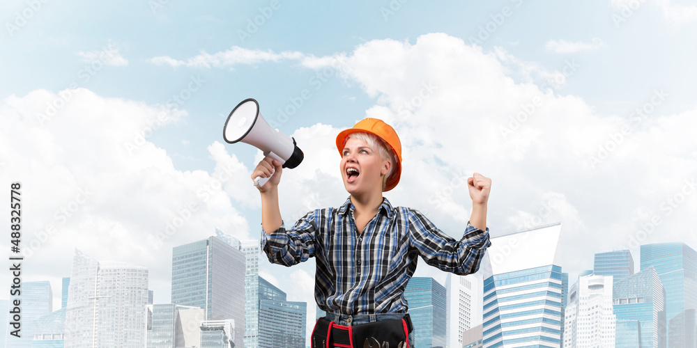 Expressive woman in helmet shouting into megaphone