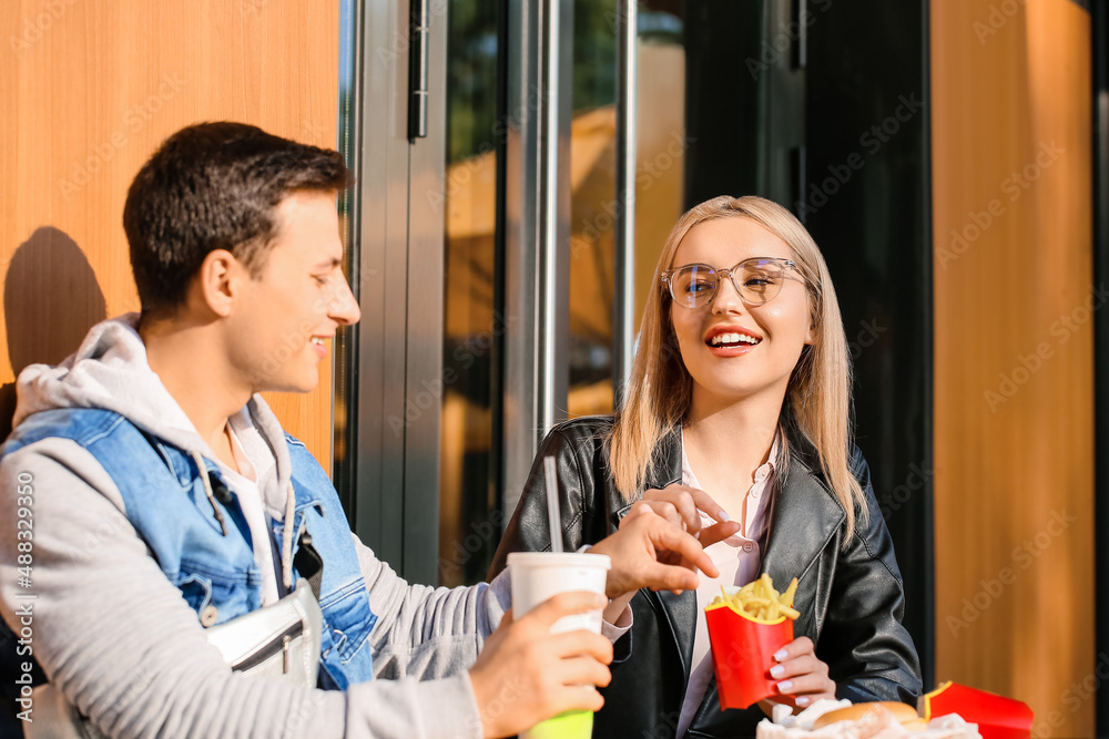 年轻夫妇在户外咖啡馆吃薯条