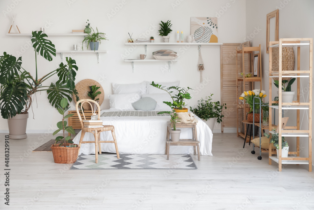 Stylish interior of modern bedroom with houseplants