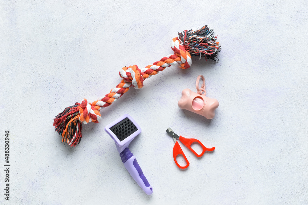 Dispenser with pet waste bags and accessories on light background