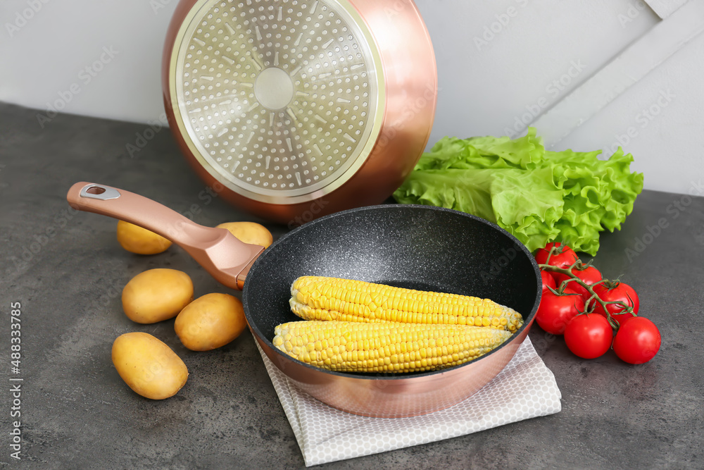 Frying pan and ingredients on table near light wall