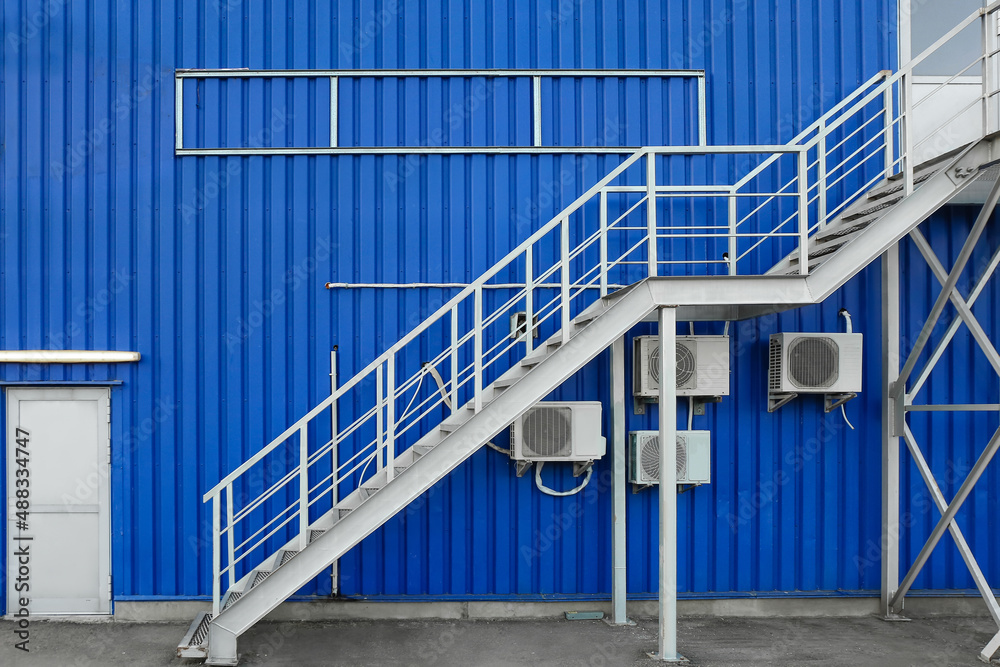 Modern metal stairs of blue building outdoors