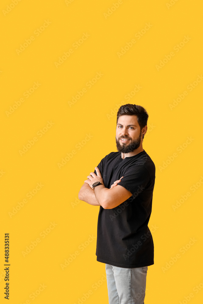 Handsome man in black t-shirt on yellow background