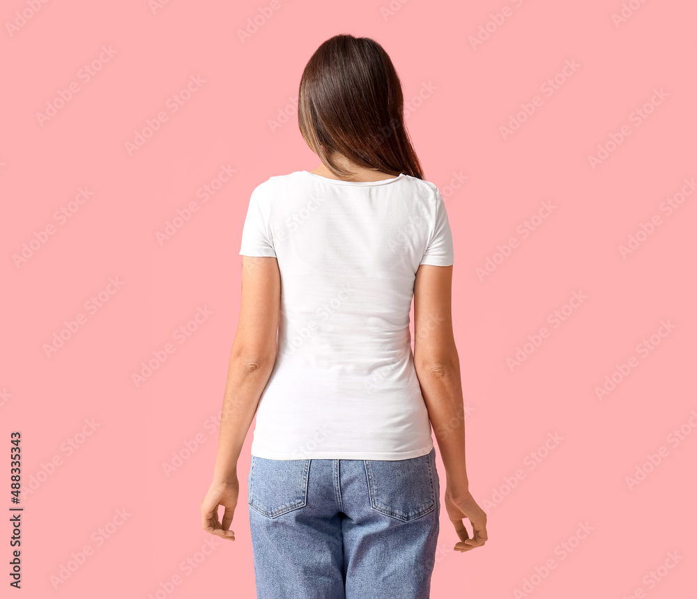 Young woman in blank t-shirt on color background, back view