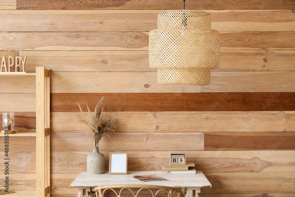 Interior of stylish room with modern workplace, shelving unit and hanging lamp