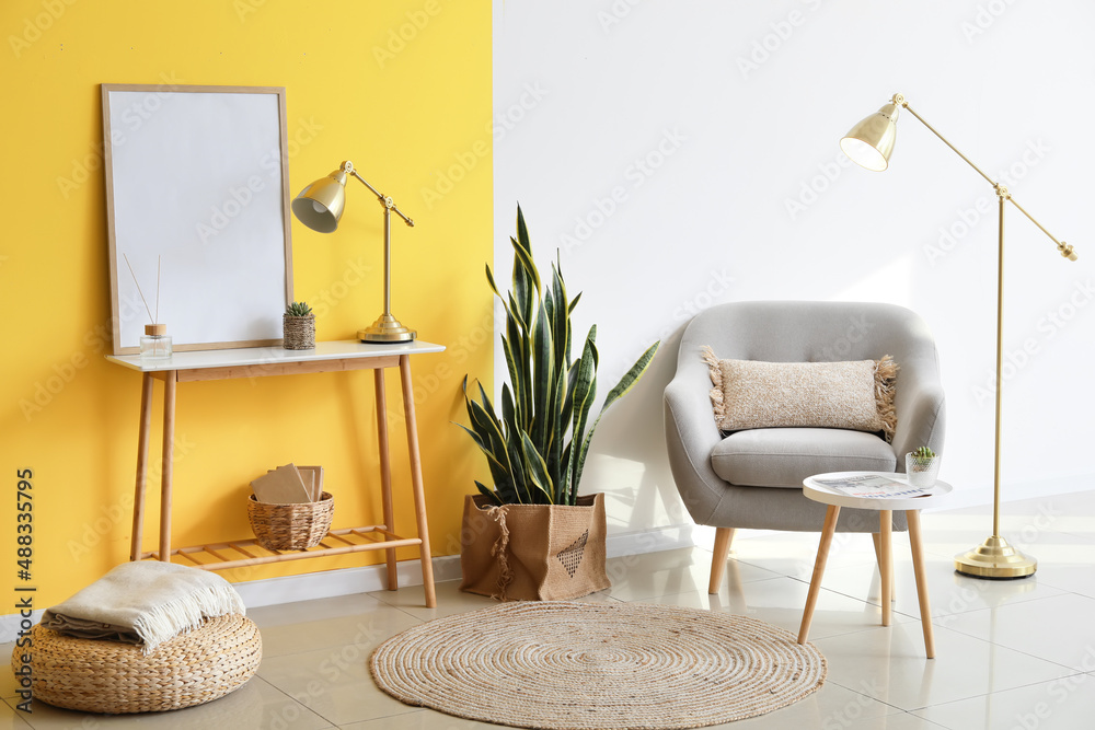 Interior of stylish living room with armchair, tables and golden lamps