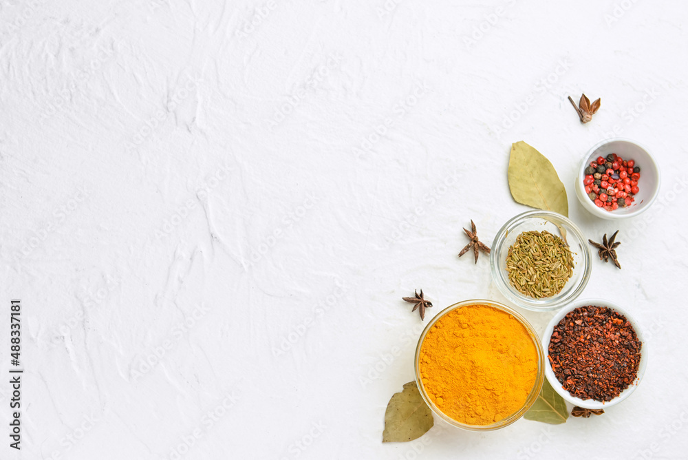 Bowls of aromatic spices on light background