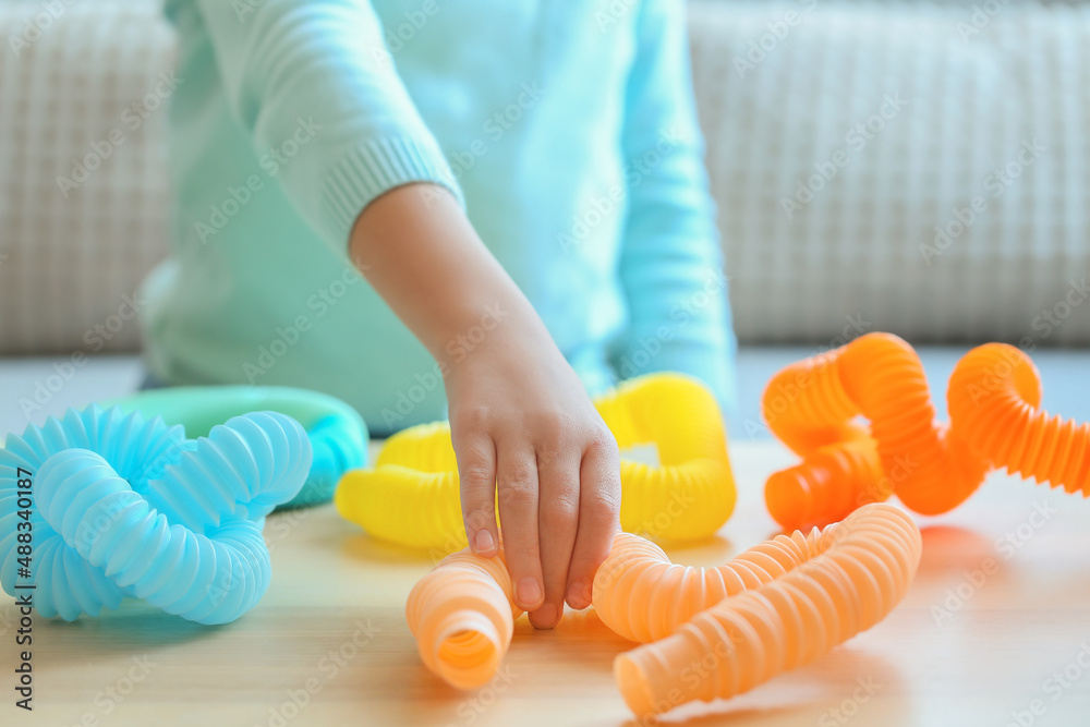 Little girl playing with Pop Tubes at home, closeup