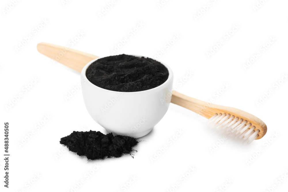 Bowl with activated charcoal tooth powder and toothbrush on white background