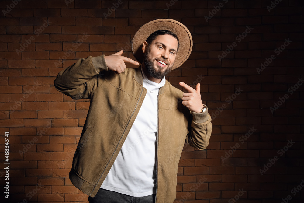 Stylish bearded man against brick wall