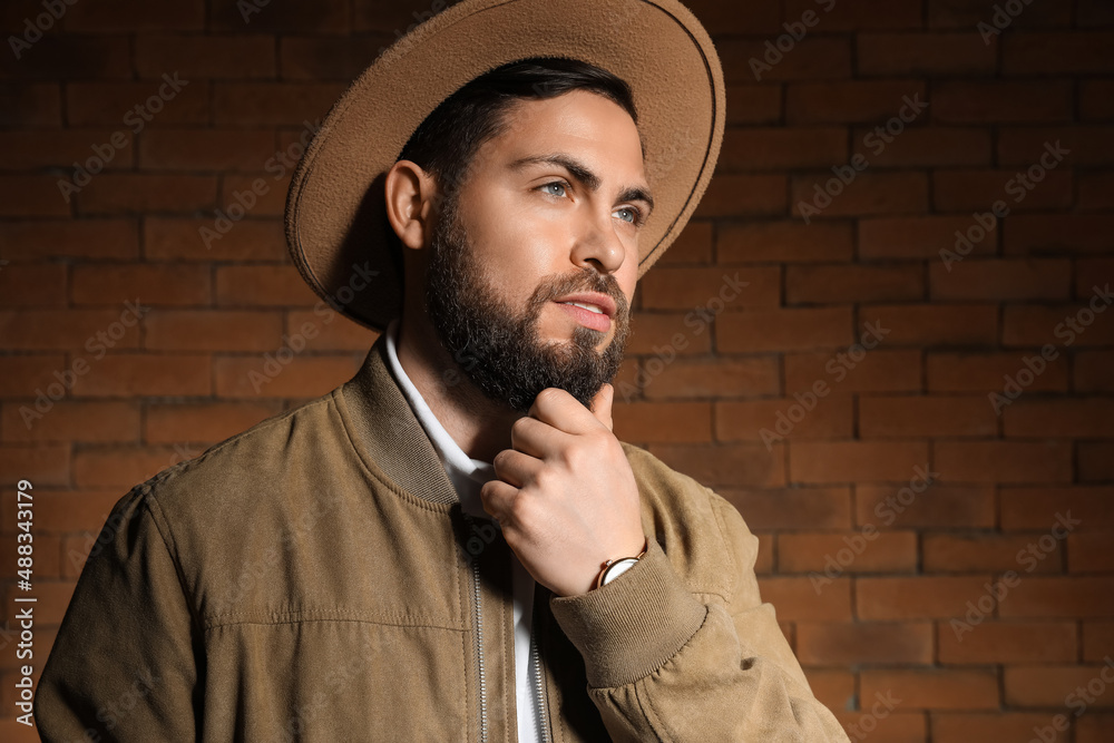 Stylish bearded man against brick wall