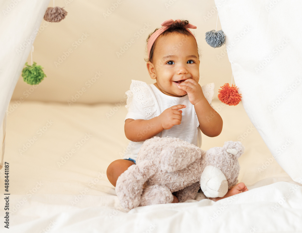 Cute adorable african american little baby girl infant wearing pink bow headband in teepee tent