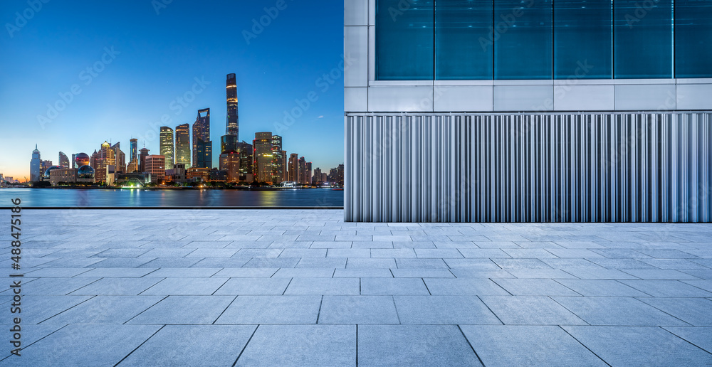 Empty square floor and city skyline with buildings in Shanghai at night, China.