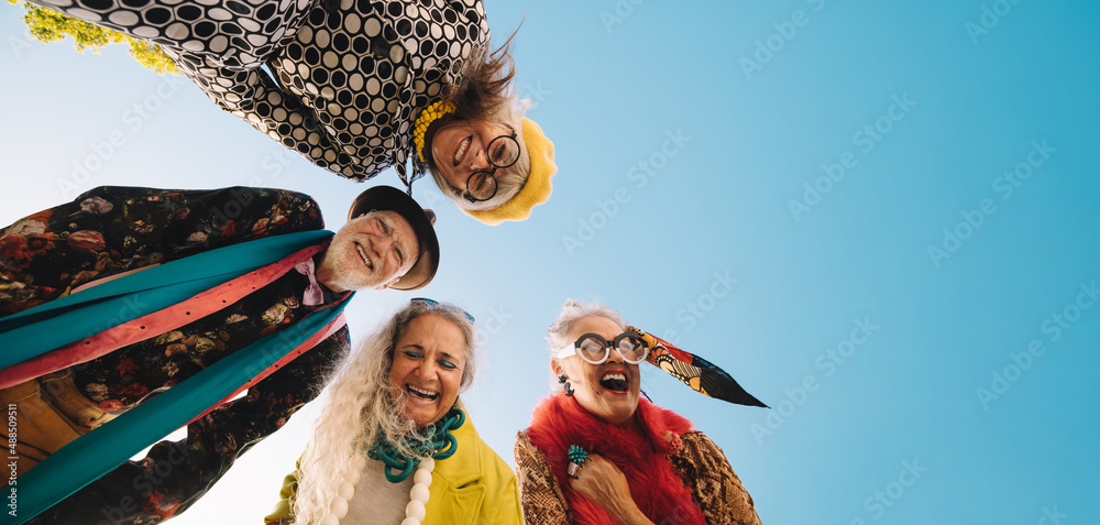 Low angle view of cheerful elderly people laughing with joy