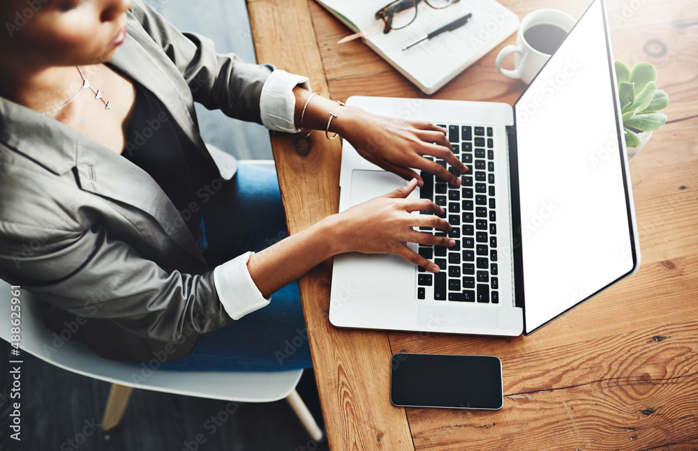 Its all happening online. High angle shot of an unrecognizable businesswoman working on a laptop in 