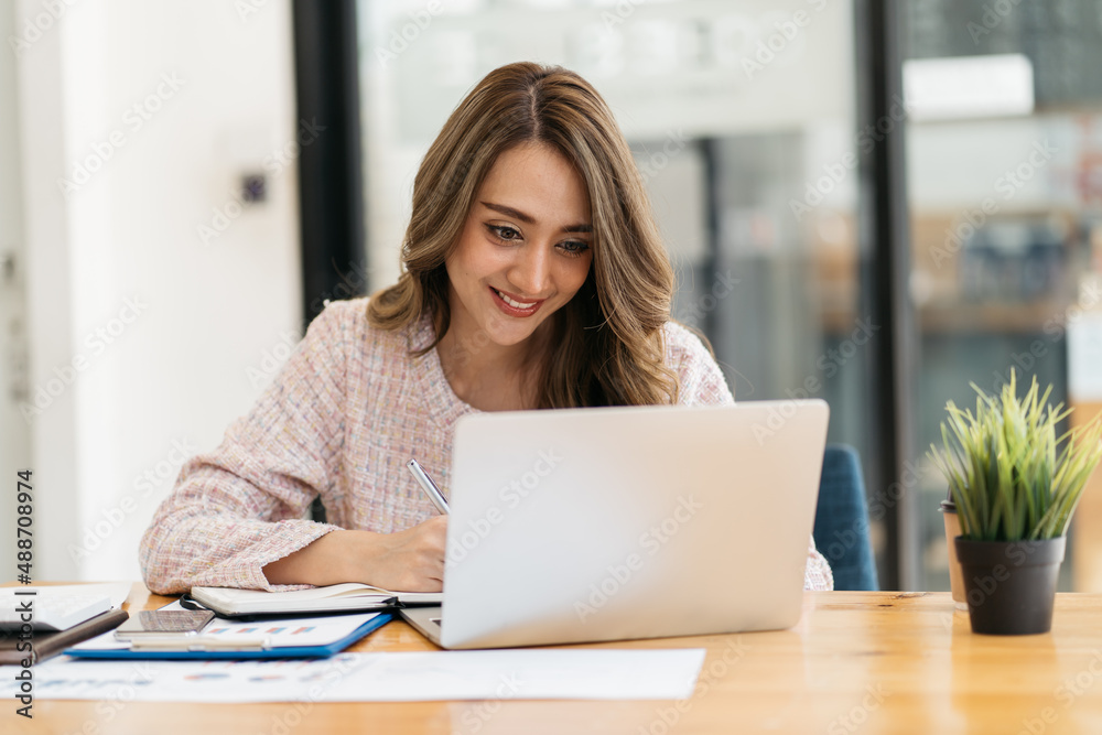 Young attractive business asian woman talking about sale report in video call conference on notebook