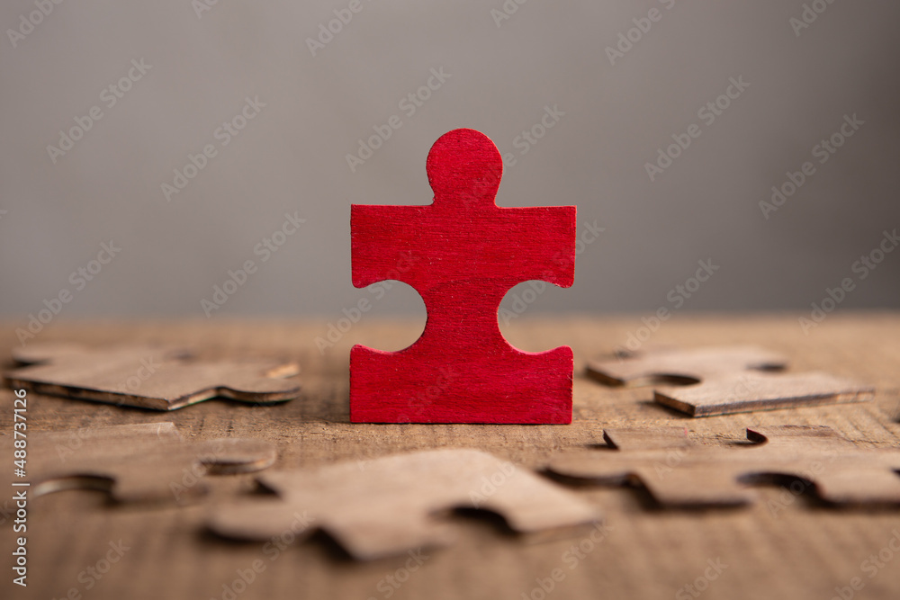 Creative idea and solve the problem concept. Teamwork success strategy - wooden puzzle on the grey b