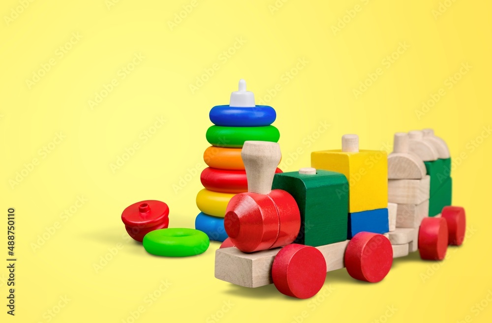 Baby kids toys background. Wooden toy train, wood stacking pyramid tower and colorful wood bricks