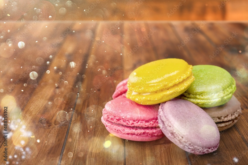 French dessert for coffee. Multicolored macarons or macaroons on desk