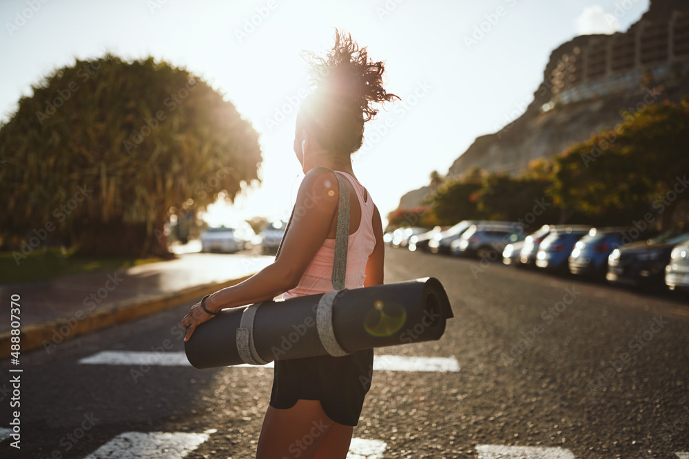 Sporty woman crossing a street on her way to yoga