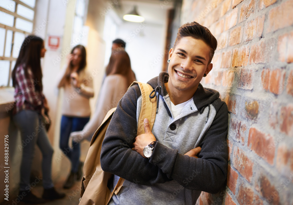 朋友让大学变得有趣。一位英俊的年轻男学生的肖像靠在墙上。