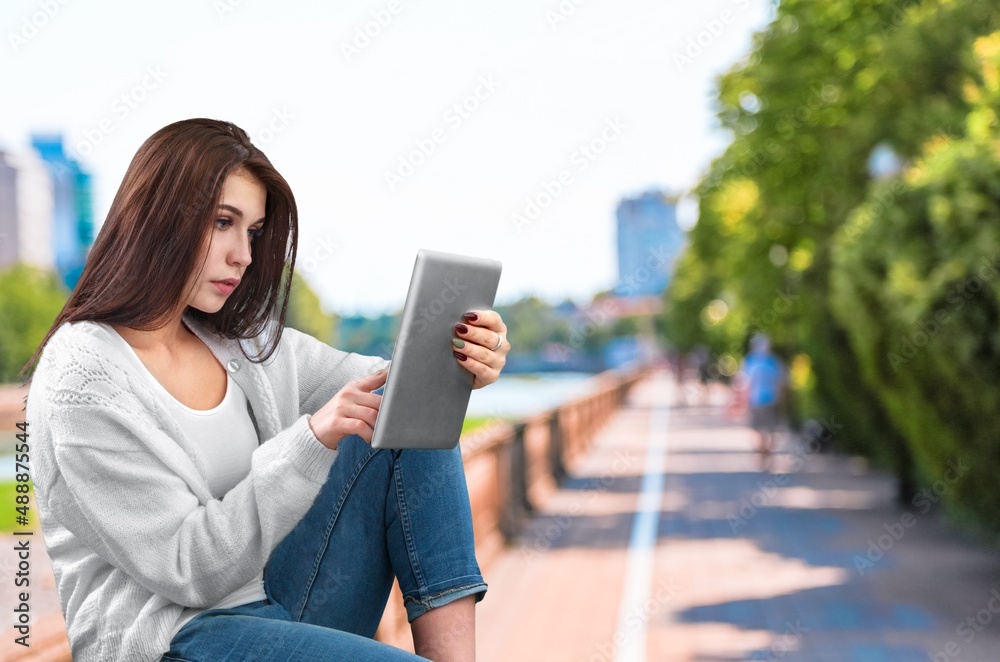 Young student freelancer using digital tablet reading e-book, working remotely, surfing on Internet