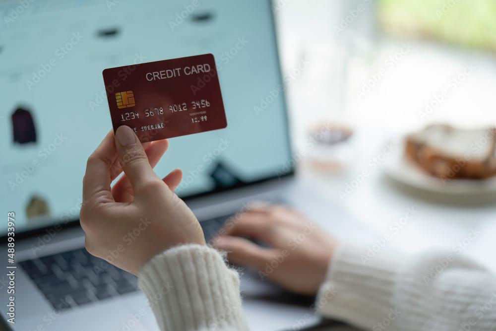 Female hands holding credit card and using laptop. Online shopping