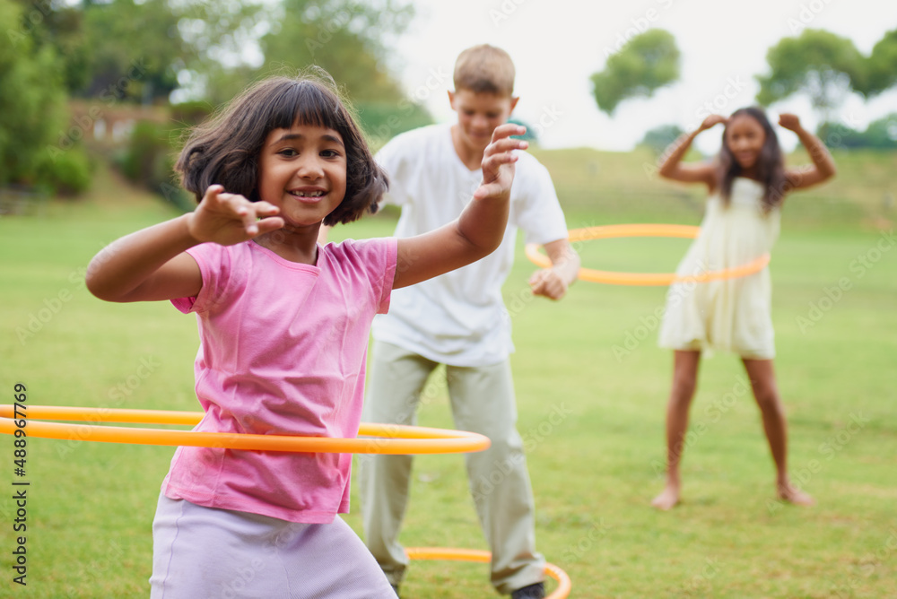 Spin like yourve never spun before. Three children playing with hula hoops outside.