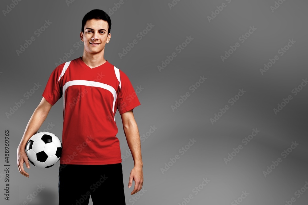 Professional football soccer player standing with ball