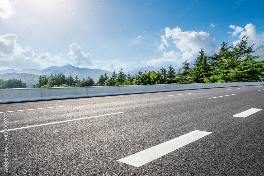 蓝天下的乡村道路和绿色森林，山景