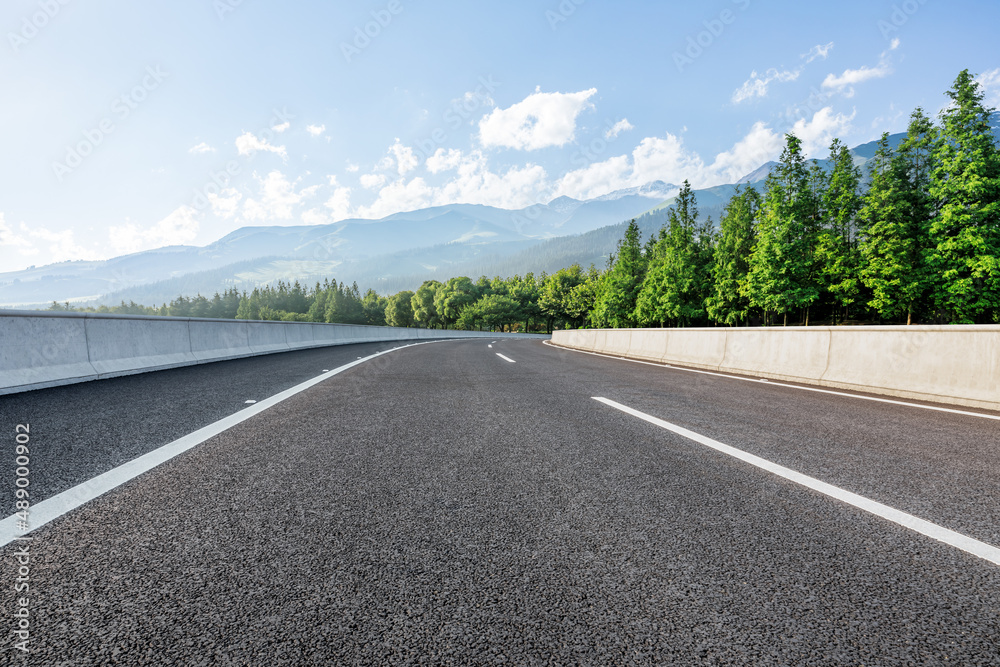 蓝天下的乡村道路和绿色森林，山景