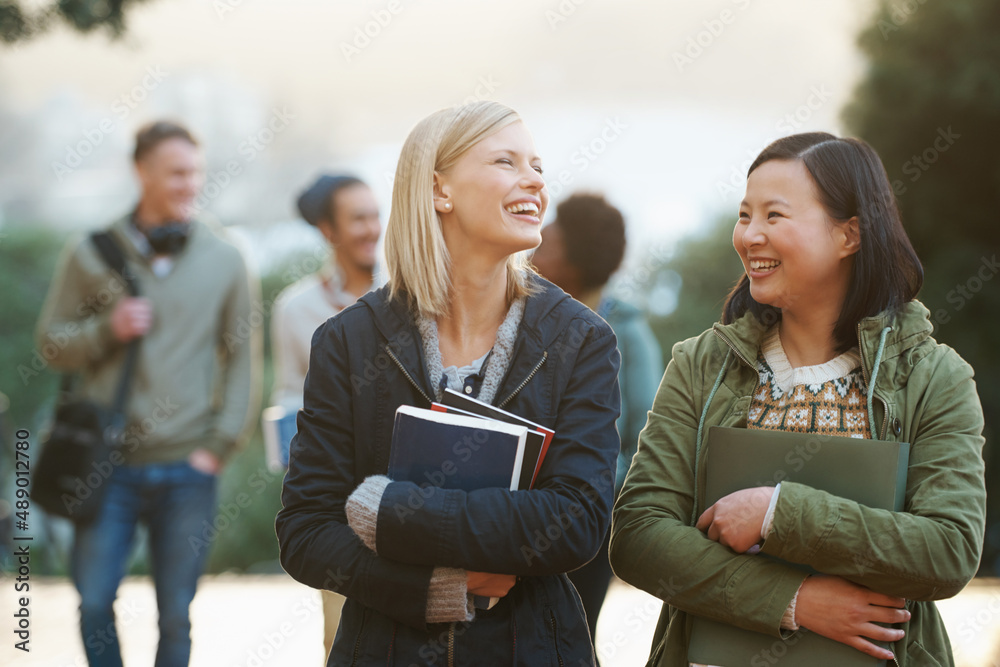 College life. Shot of a college students between classes on the campus grounds.