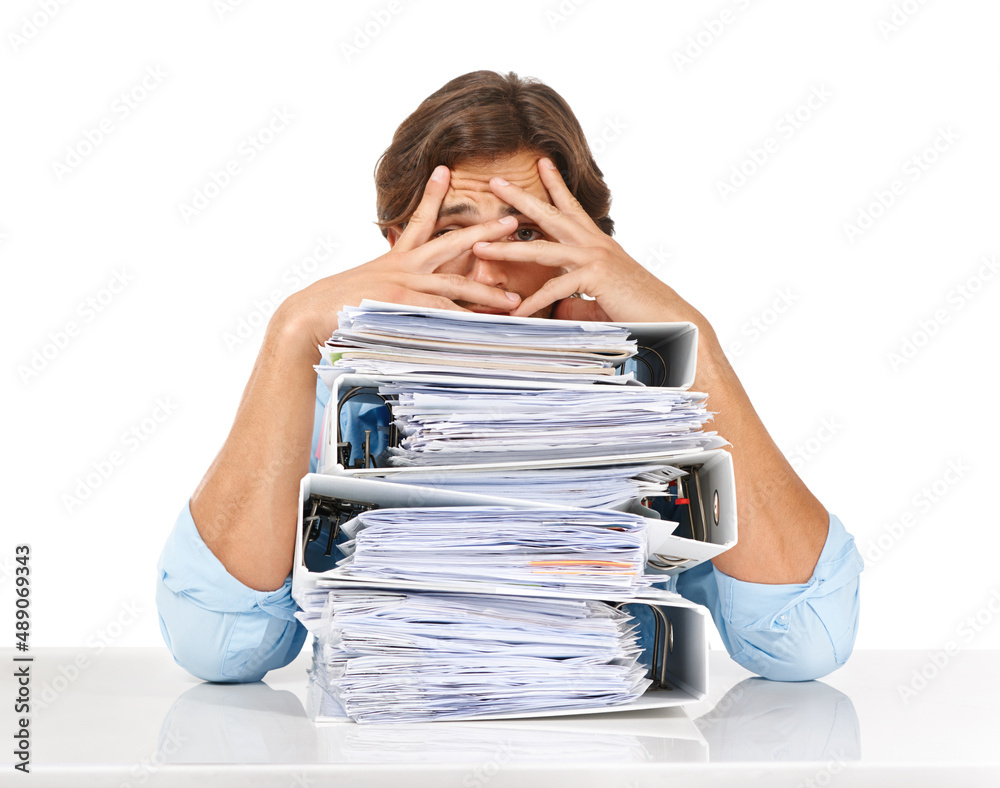 The paperwork just keeps piling up. Studio shot of a businessman sitting with a pile of files and lo