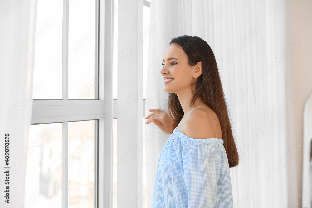 漂亮的年轻女人靠近窗户