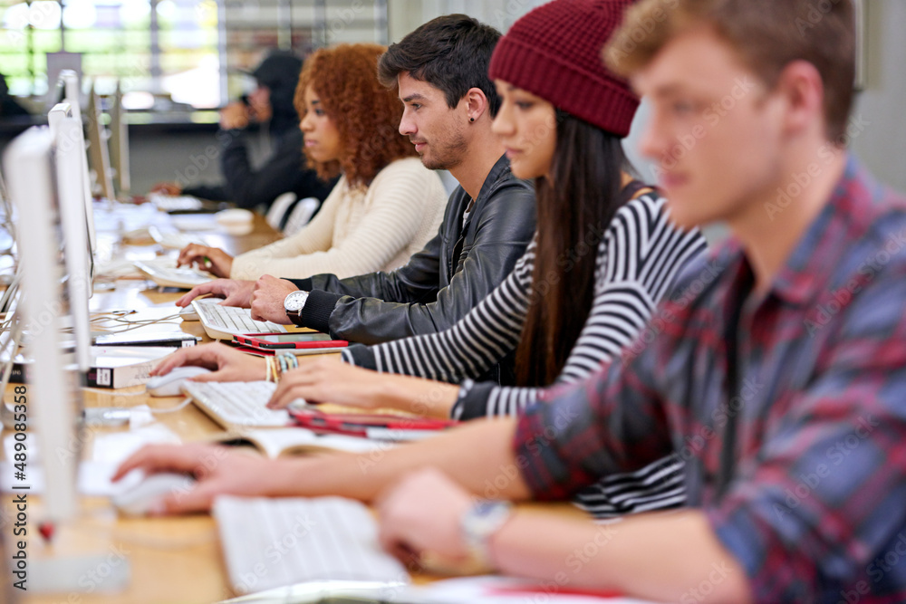 Focussed on their studies. Shot of students working on computers in a university library.