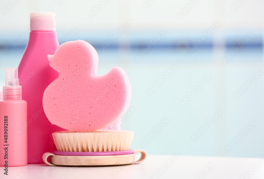 Set of bath supplies with sponge on table