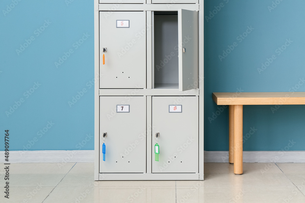 Modern locker and bench near blue wall