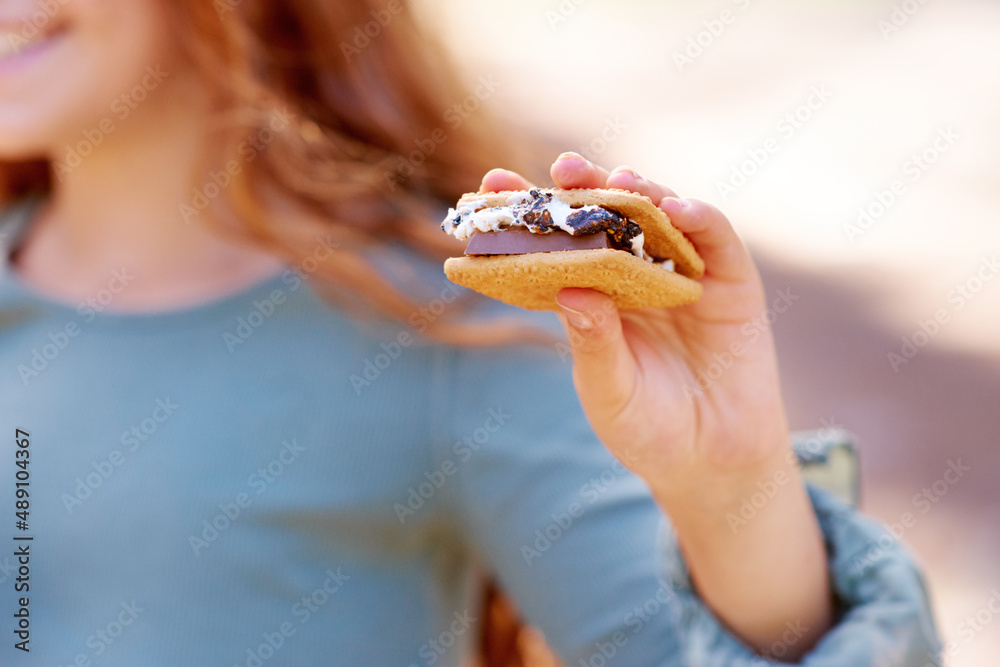 完美的露营地美食。一个小女孩拿着美味的烟熏的裁剪图。