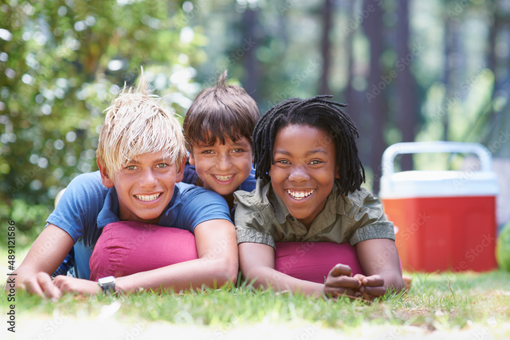 We are ready to have fun. Shot of young boys lying on the grass.