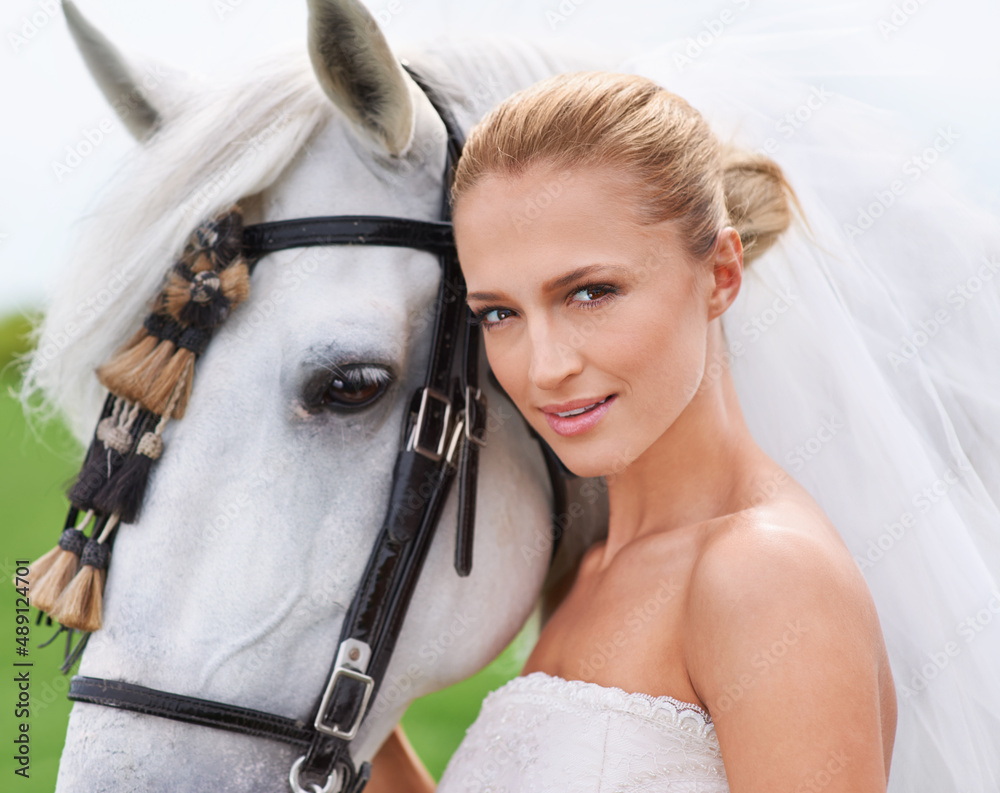 Her most trusted steed will spirit her to the aisle. Portrait of a gorgeous blonde bride standing al