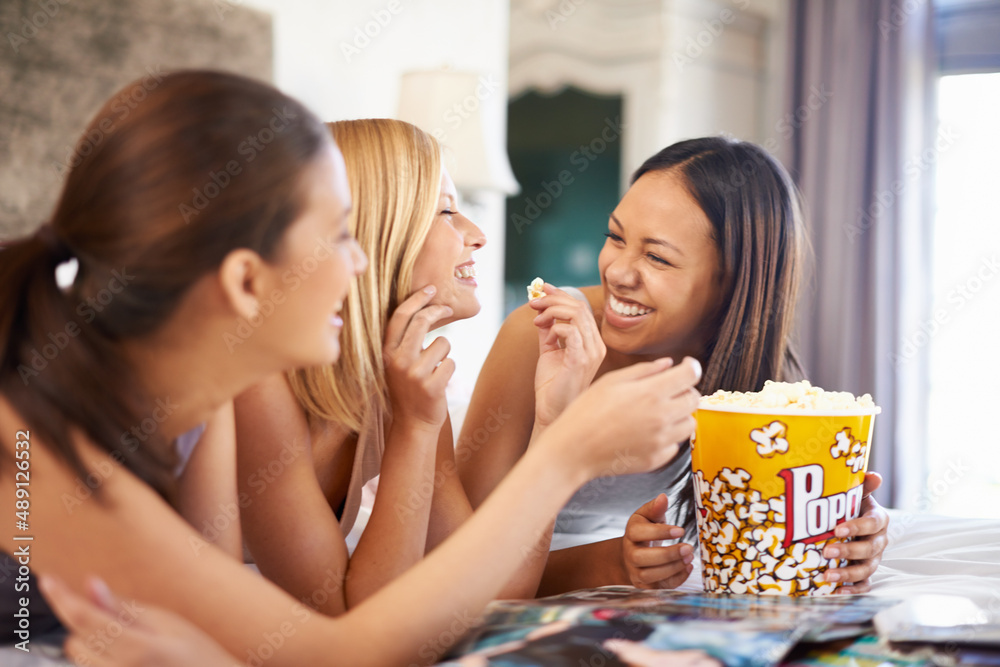 We havent done this in ages. Shot of three attractive young women eating popcorn on their girls nigh