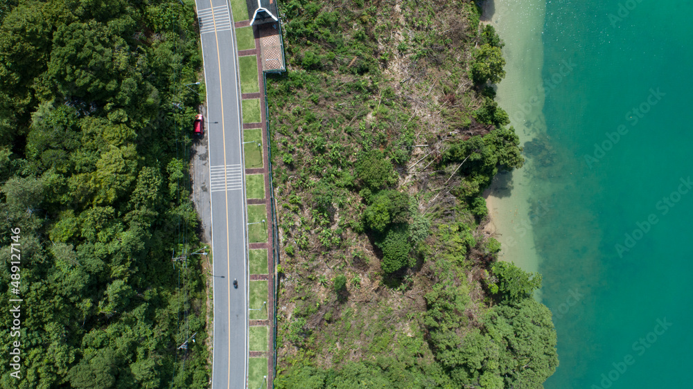 Aerial view top view seashore with asphalt road curve in Tropical island Amazing nature view Beautif