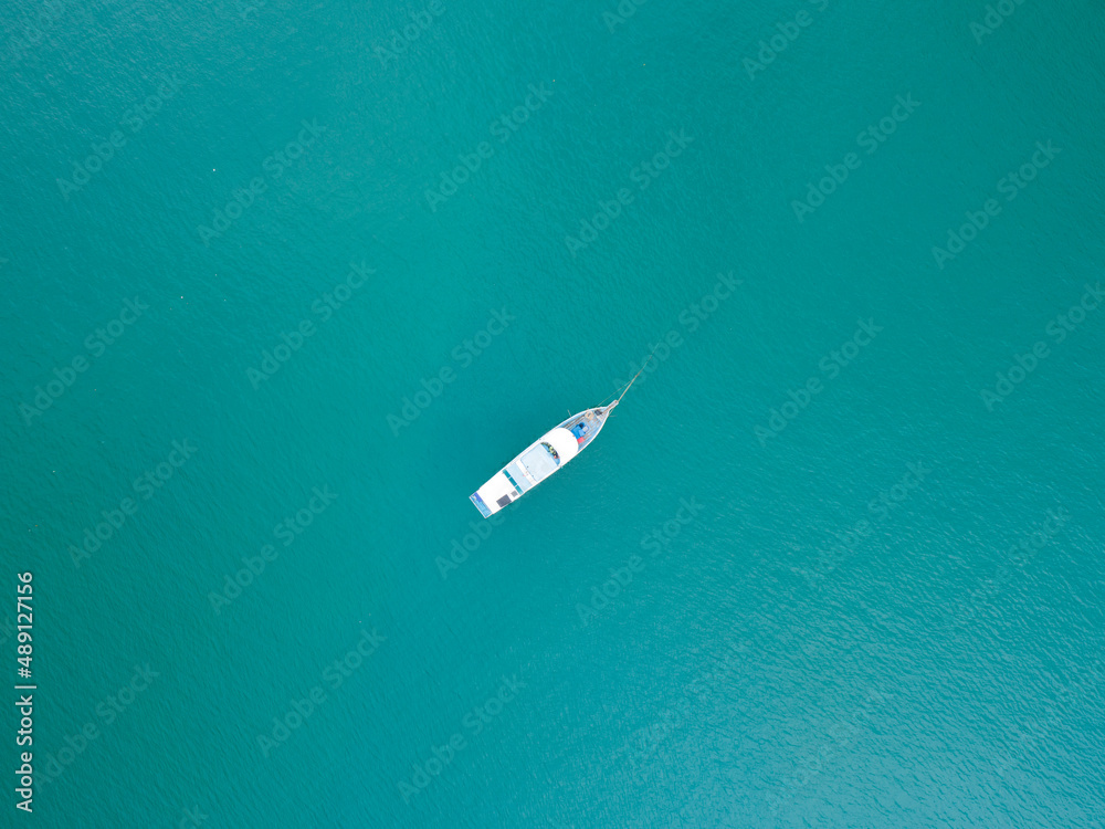 Aerial top view photo of traditional wooden fishing boat in tropical sea Phuket island Beautiful tur