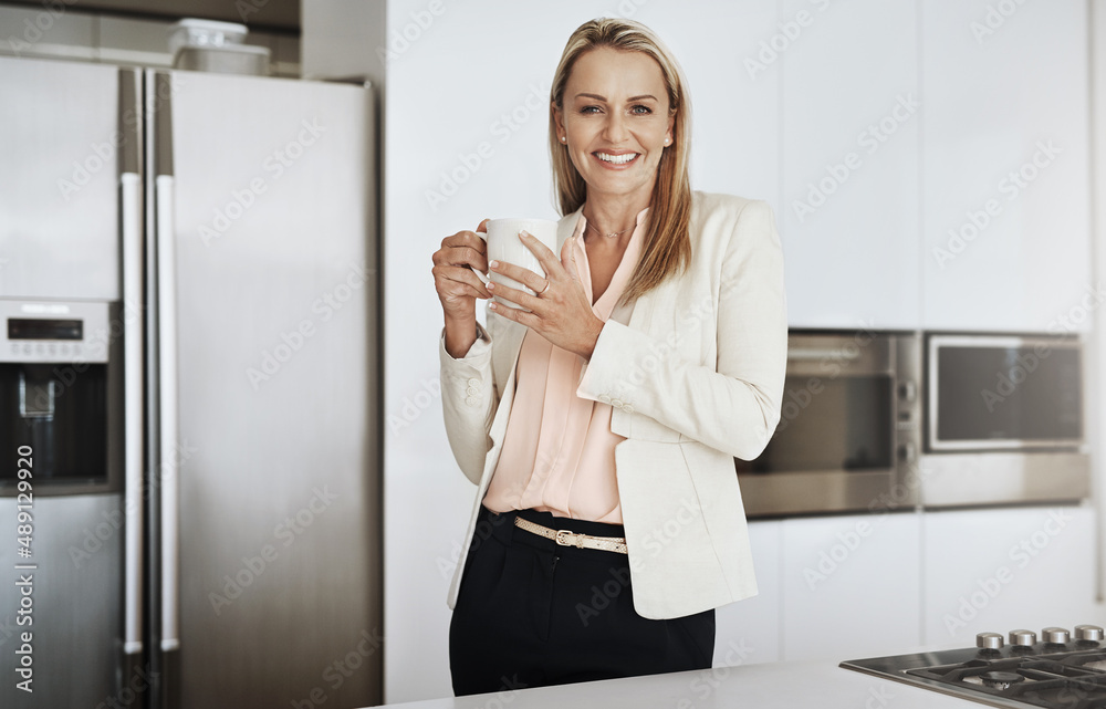 Got to keep on the go. Portrait of a cheerful middle aged businesswoman standing behind a counter wh